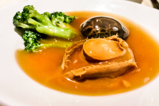 Closeup on abalone with mushroom and broccoli dish. Expensive Chinese dish during celebration