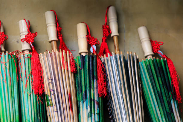 Colorful paper umbrellas arranged on a wall for sale in Asia