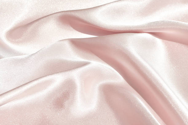 istock Charming smooth satin and silk pink fabric for backgrounds. Elegant abstract upholstery use for holidays 1153965556