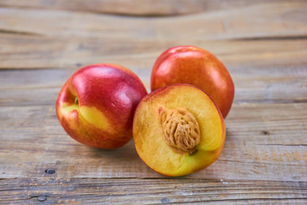 istock Ripe nectarine  isolated on wood background. 1153970485