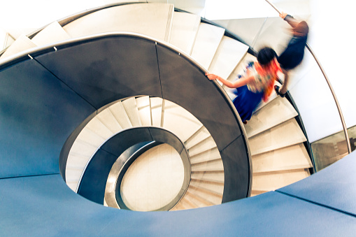 Desenfoque de movimiento de las personas en la escalera de caracol abstracta photo