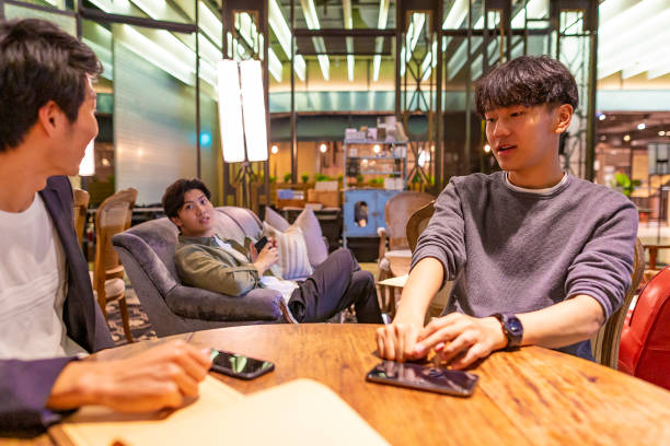 istock Happy Asian Men Ordering From Menus in a Coffee Shop 1153973768