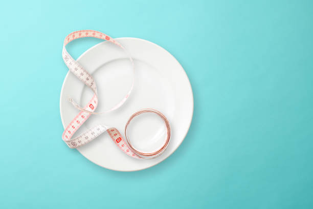 istock White plate with Tape Measure on light blue background 1153979466
