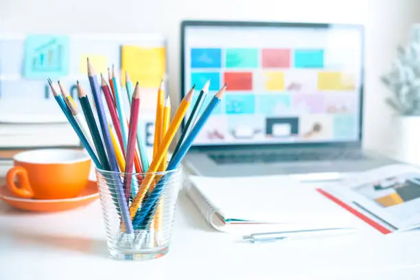 Photo of Colorful pencil in glass on desk table in home office.business creativity