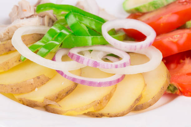Chicken salad with onion and potato. Close-up.