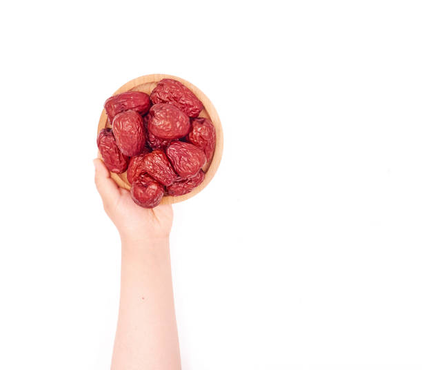Female hand holding Jujube on a white background