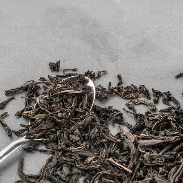 istock Dried tea and a spoon on a gray textured background. 1153983893