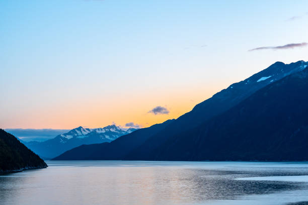 zachód słońca za ośnieżonymi górami żeglujących po oceanie w skagway na alasce w sezonie jesiennym - snow capped mountain peaks zdjęcia i obrazy z banku zdjęć
