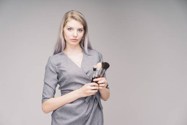 Young woman having serious face expression and beautiful colorful makeup, eyes closed. Visage beauty concept.