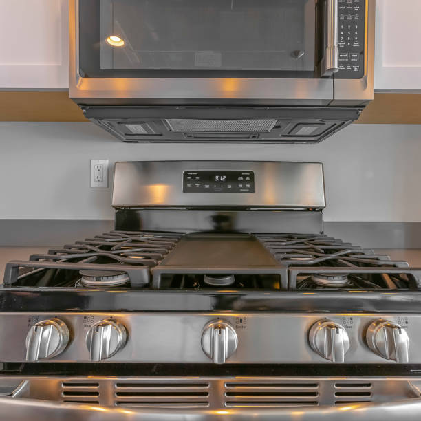 istock Square Close up of wall mounted microwave and cooktop of a range inside the kitchen 1153995193