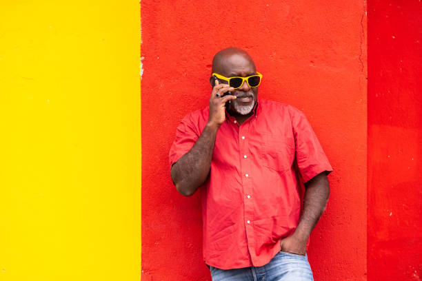 istock Mature afro man on colorful background talking on a smartphone 1153996683