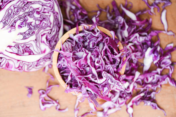 istock Cabbage purple - Shredded red cabbage slice in a wooden bowl top view 1153997383
