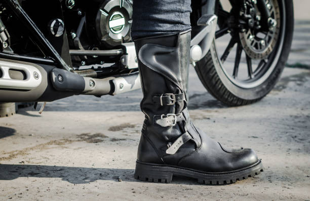 biker leg in a boot against the backdrop of a motorcycle biker leg in a boot against the backdrop of a motorcycle boot stock pictures, royalty-free photos & images