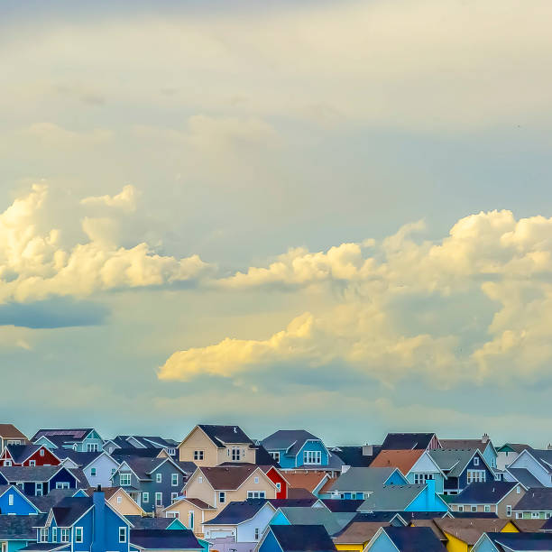 istock Square Panoramic view of houses under vast sky filled with illuminated puffy clouds 1153997695