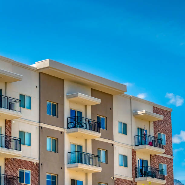 istock Square Serene blue sky with puffy clouds over a residential building on a sunny day 1153997762