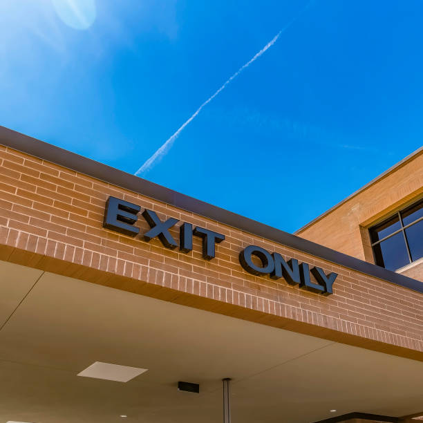 istock Square Exit Only sign on the exterior of a building against blue sky on a sunny day 1153997777