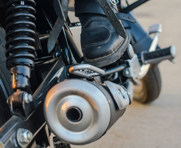 istock moto biker boots on motorcycle background close-up 1153997816