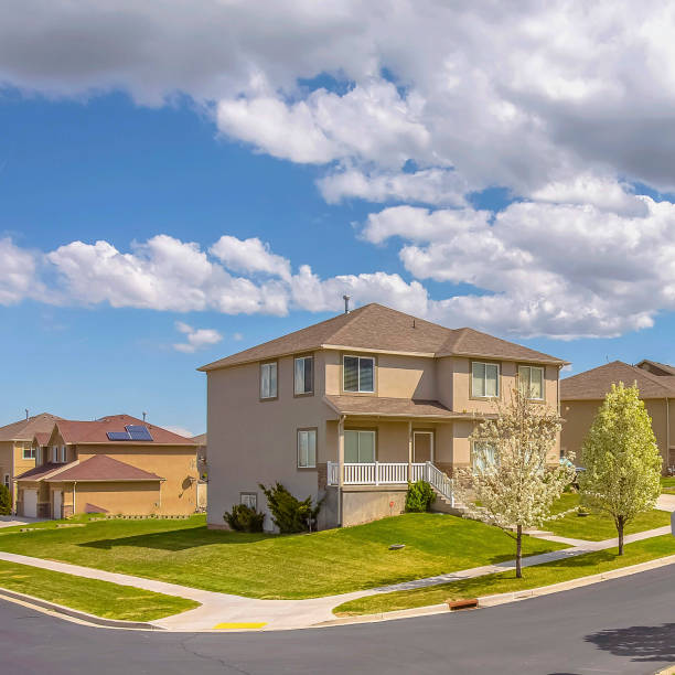 istock Frame Square Paved road along lovely homes under blue sky with puffy clouds on a sunny day 1153999977