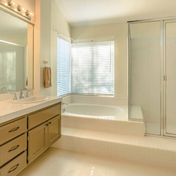 istock Frame Square Bathtub and double vanity unit inside the well lighted bathroom of a home 1153999998