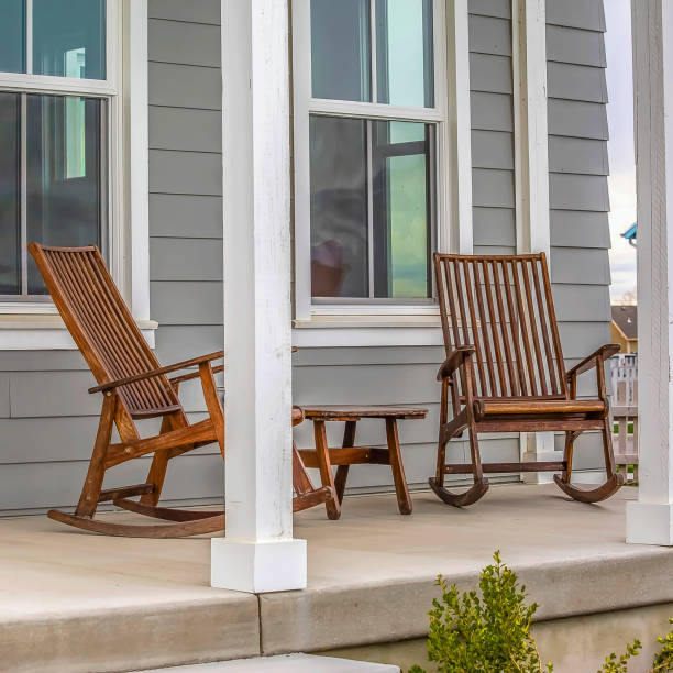 istock Frame Square Front porch of a house with brown rocking chairs and rectangular white pillars 1154000034
