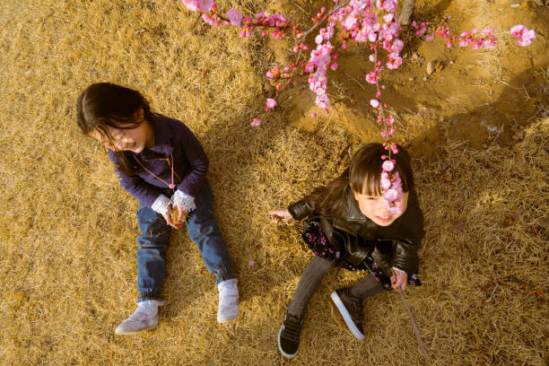 two young girls sitting on the grass