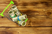 kleiner-einkaufswagen-mit-rollen-von-hundert-dollar-rechnungen-auf-holzhintergrund-konzept.jpg?b=1&s=170x170&k=20&c=Pj-xTkRXzp3nwbjqr9p4ZH_Ci4AVnrwT8aGxhAyjXVU=