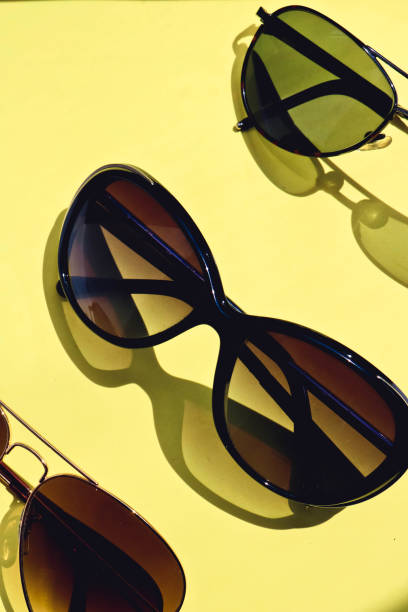 istock Sunglasses with shadows on colorful yellow background. 1154004483