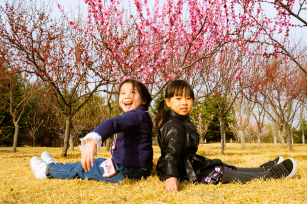 istock two young girls sitting on the grass 1154004558