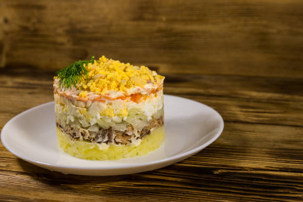istock Traditional russian salad Mimosa on wooden table 1154005190