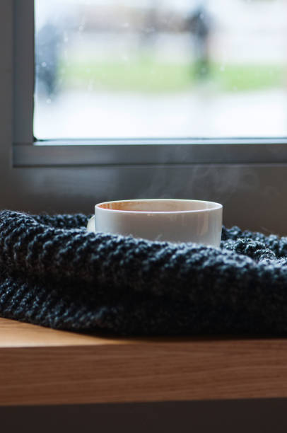 istock Cup of americano and scarf on windowsill. 1154008981