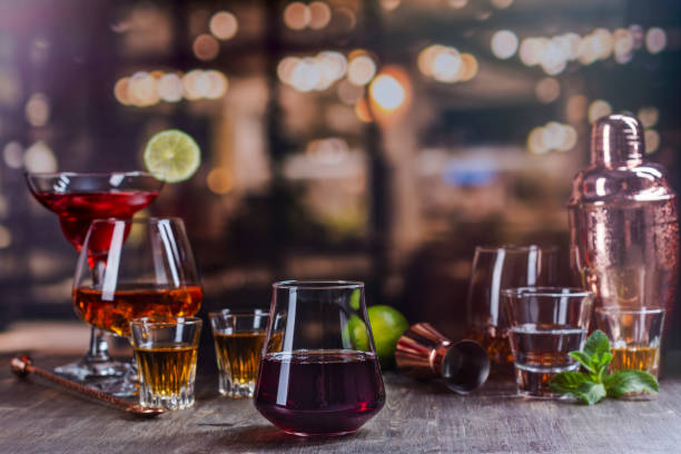 Strong alcohol drinks in bar Red wine in a glass on a bar counter. Assortment of different strong alcohol drinks over night lights background. Copy space bachelor and bachelorette parties stock pictures, royalty-free photos & images