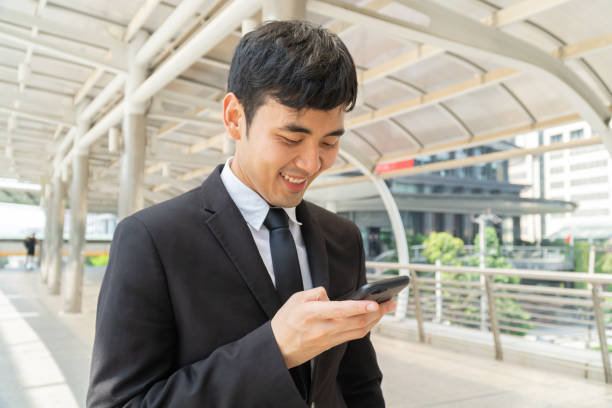istock Business man using mobile phone in formal suit. 1154010052