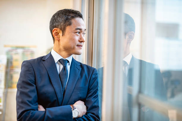 istock Male Japanese Hospital Administrator Standing at Window 1154010423