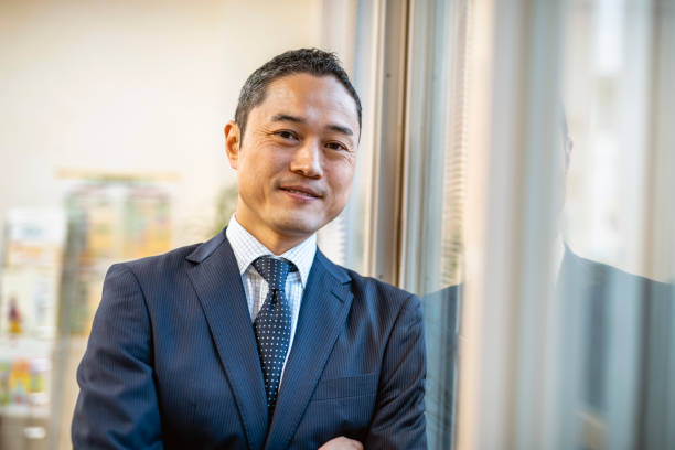 istock Male Japanese Hospital Administrator Standing at Window 1154010433