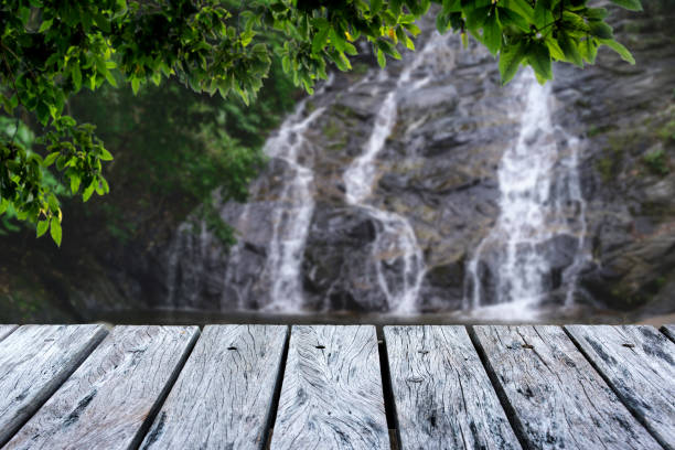 istock Wooden table in green forest and Waterfall background,For product display. Beautiful. 1154013171
