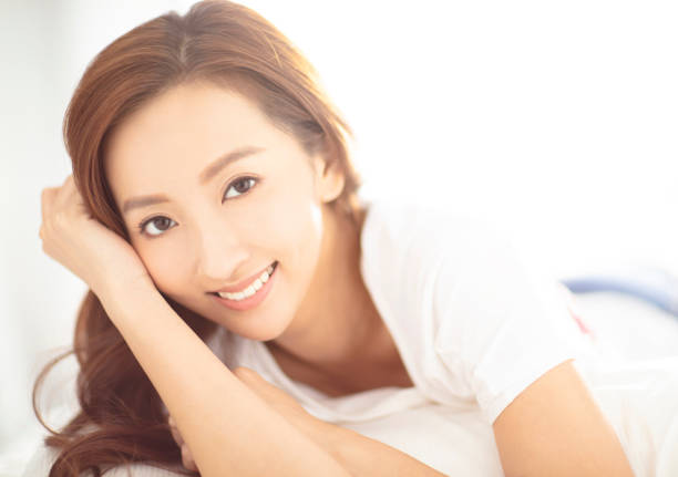 istock closeup young asian smiling woman on bed 1154014426
