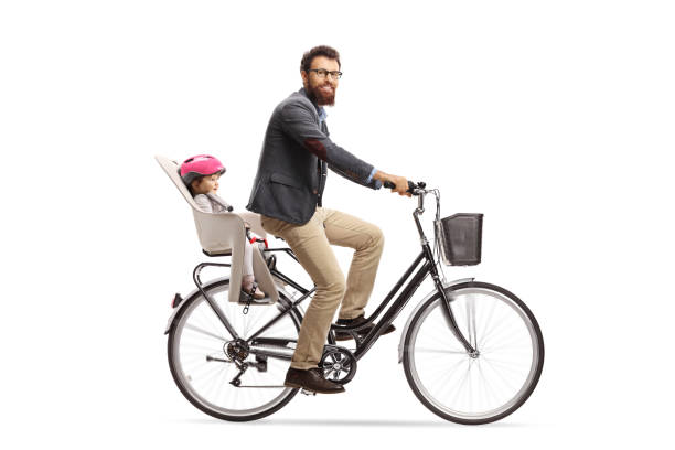 bearded man riding a little child on a bicycle and looking at the camera - helmet bicycle little girls child imagens e fotografias de stock