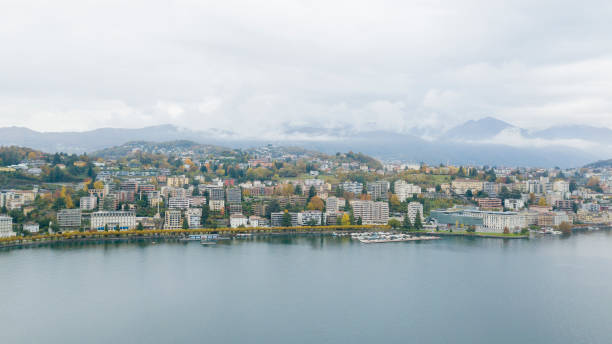 vista aérea de los drones del lago de lugano en la ciudad de lugano en ticino durante un día de verano. vista de la ciudad desde arriba, del lago y las montañas en el fondo - switzerland ticino canton lake lugano fotografías e imágenes de stock