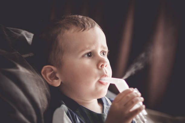 istock Two year old boy making inhalation with nebulizer at home. 1154020062