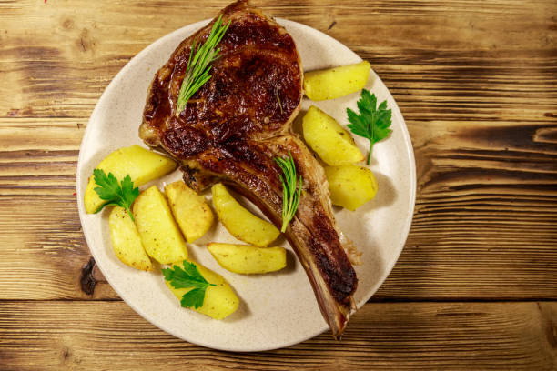 구운 감자와 나무 테이블에 허브가 있는 뼈에 구운 쇠고기 갈비 눈 스테이크 - sirloin steak baked potato beef gourmet 뉴스 사진 이미지