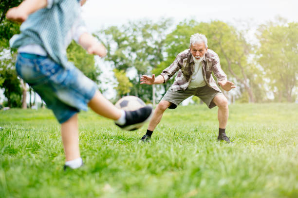 Grandfather and grandson enjoy a game. Shadow DOF. Developed from RAW; retouched with special care and attention; Small amount of grain added for best final impression. 16 bit Adobe RGB color profile.