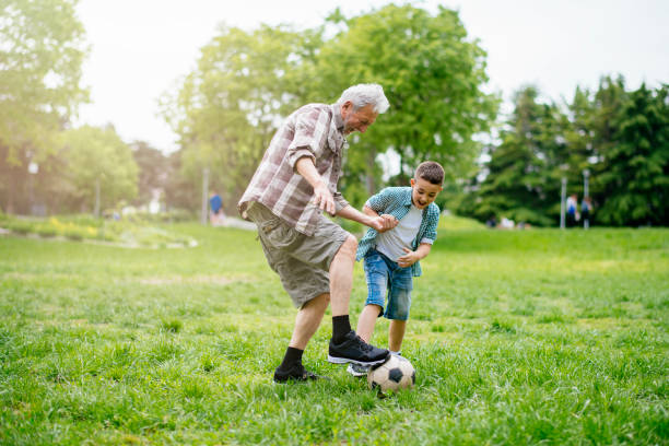 おじいちゃんと孫は楽しんで、サッカー - helmet child padding football helmet ストックフォトと画像