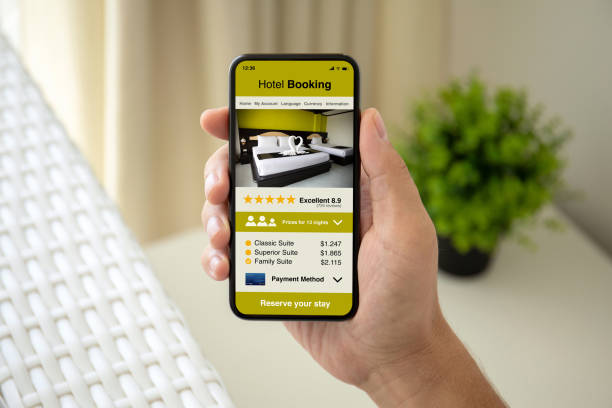 istock man hand holding phone with app hotel booking on screen 1154028645