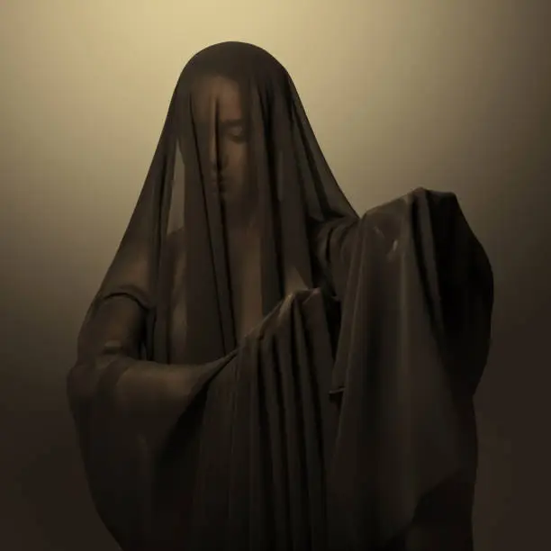 Photo of Girl in a black transparent veil on the face. Conceptual portrait in the studio. Minimalism.