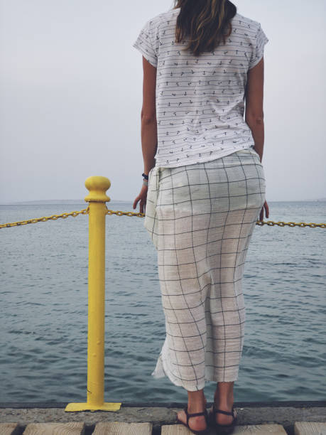 istock Lonely woman standing on a sea / ocean shore. 1154030961