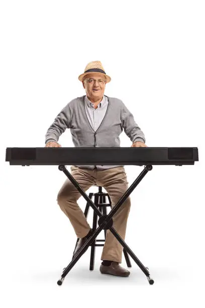 Photo of Senior man sitting and playing a keyboard