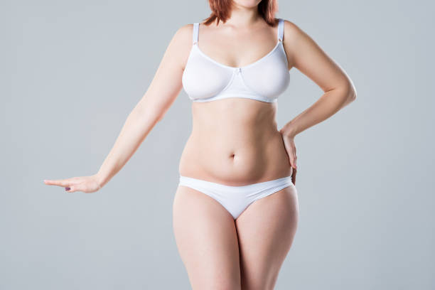 frau mit fettem bauch-bauch, übergewichtiger weiblicher körper auf grauem hintergrund - overweight tummy tuck abdomen body stock-fotos und bilder
