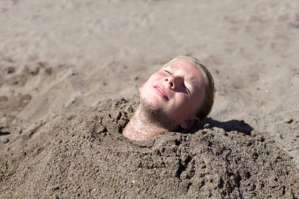 istock Girl buried in sand 1154032898