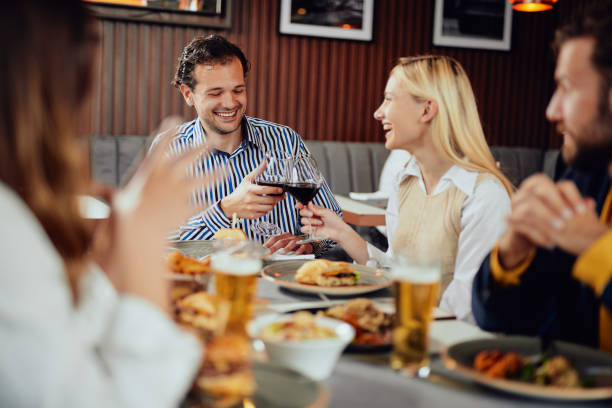 istock Friends toasting while sitting in restaurant. 1154034543