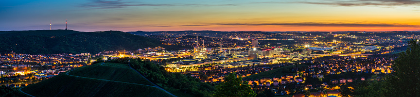 Germany, XXL panorama of magic illuminated skyline of downtown stuttgart city houses and arena after sunset from above